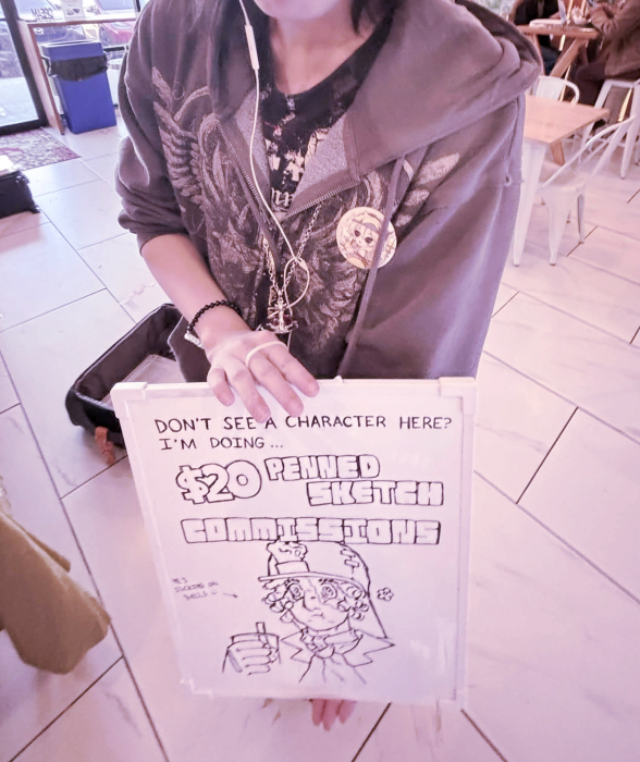 Image of a person holding up a sign that says "Don't see a character here? I'm doing $20 penned sketch commissions" depicting Norton Campbell drinking boba.